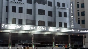 A hotel with a modern architectural design, featuring a prominent curved facade and a series of balconies.