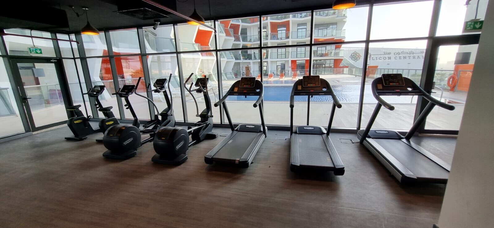 Un gimnasio con cintas de correr, elípticas y bicicletas estáticas.
