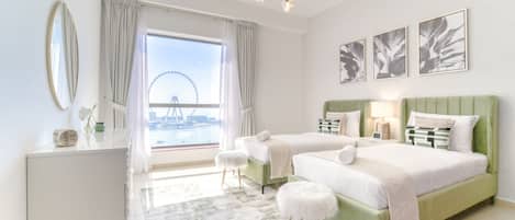 A modern hotel room with two beds, a view of a Ferris wheel, and a balcony.