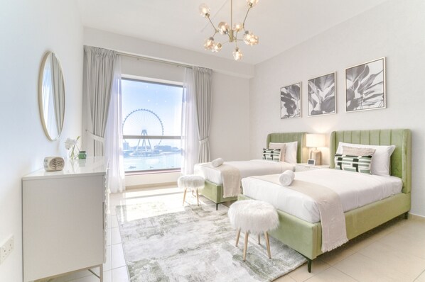 A modern hotel room with two beds, a view of a Ferris wheel, and a balcony.