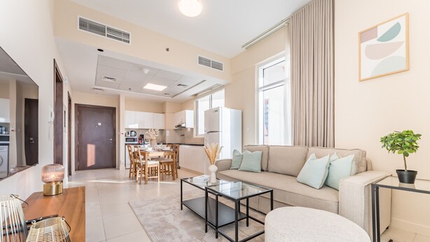 Uma sala de estar moderna com sofá, mesa de centro e uma área de jantar com cadeiras e mesa.