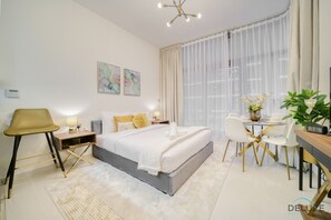 Une chambre d’hôtel moderne équipée d’un grand lit, d’un bureau, d’une chaise et d’un coin repas.