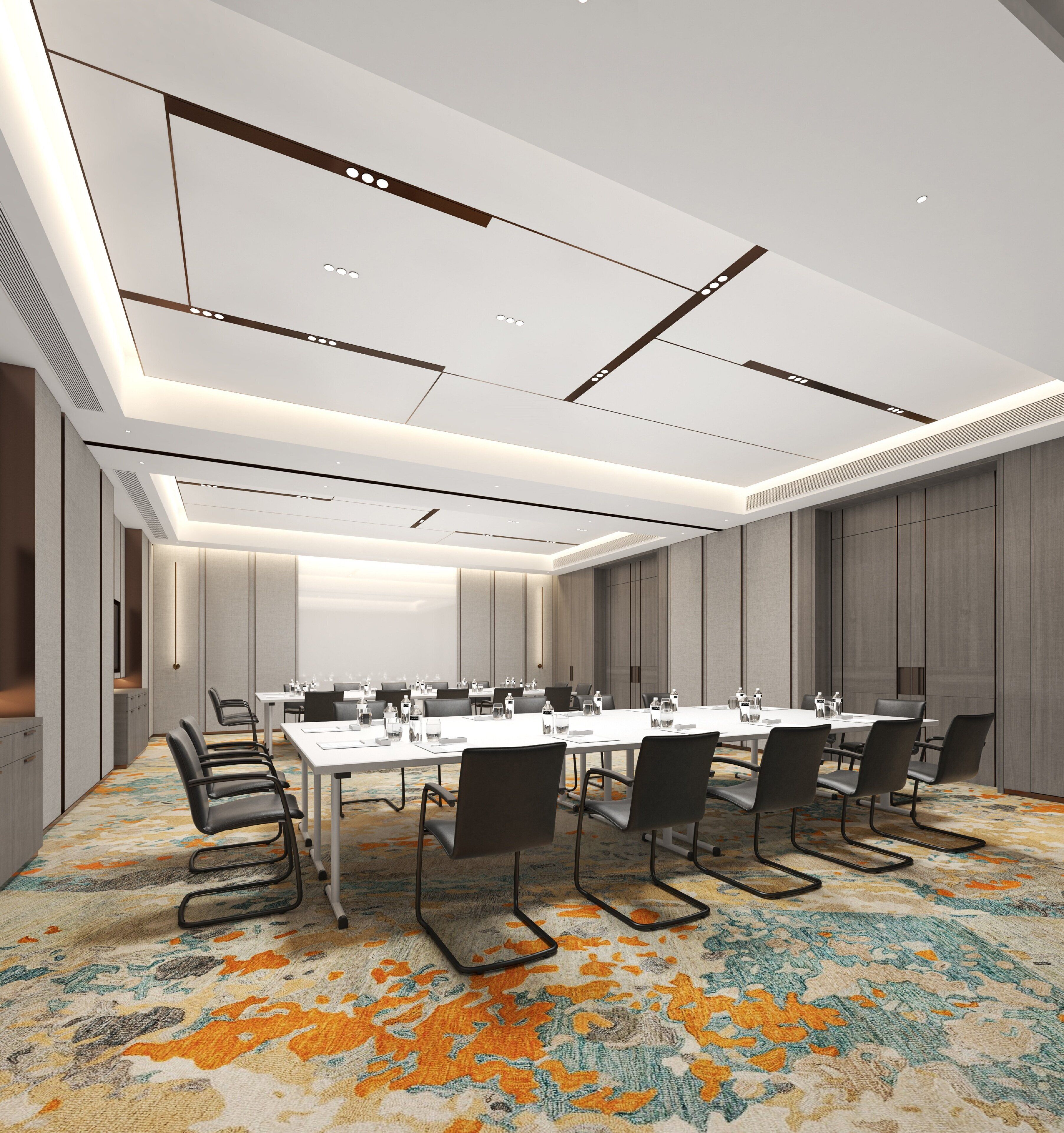 A conference room with a long table, chairs, and a carpeted floor.