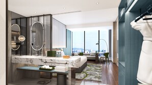 Ein modernes Hotelzimmer mit Marmorbad, einem großen Bett, einer Sitzecke und Blick auf die Stadt.