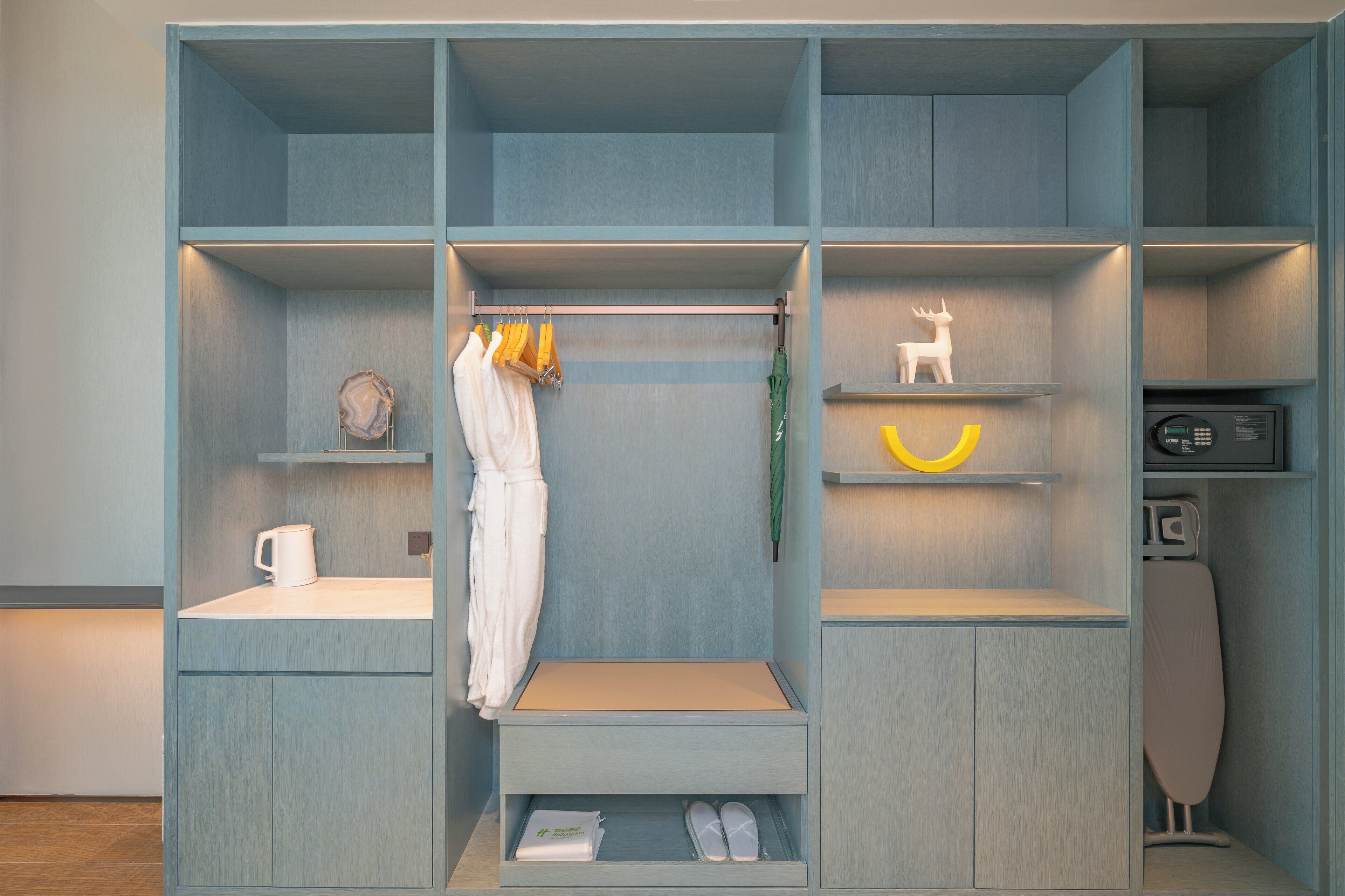 A modern closet with multiple compartments, including shelves for hanging clothes, a drying rack, and storage for shoes and toiletries.
