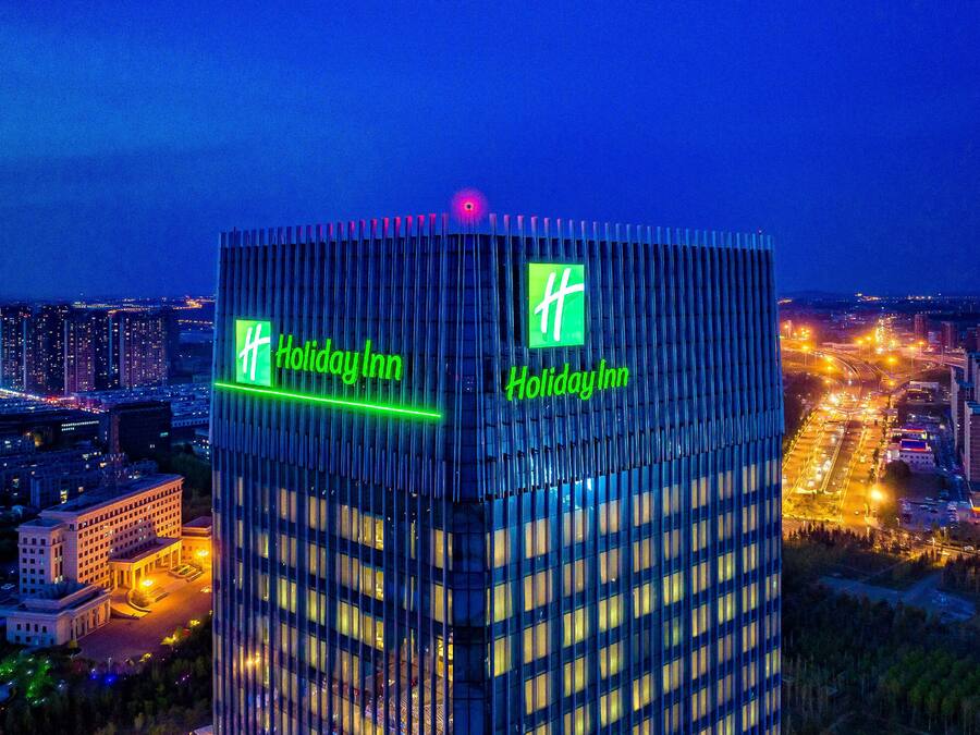 A high-rise Holiday Inn with a distinctive grid-like facade and illuminated signage.