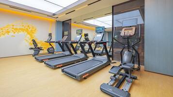 A gym with multiple treadmills, ellipticals, and a stationary bike.