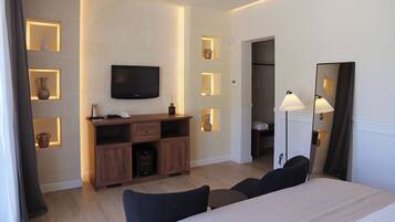 Ein Hotelzimmer mit Bett, Fernseher, Schreibtisch und Kleiderschrank.