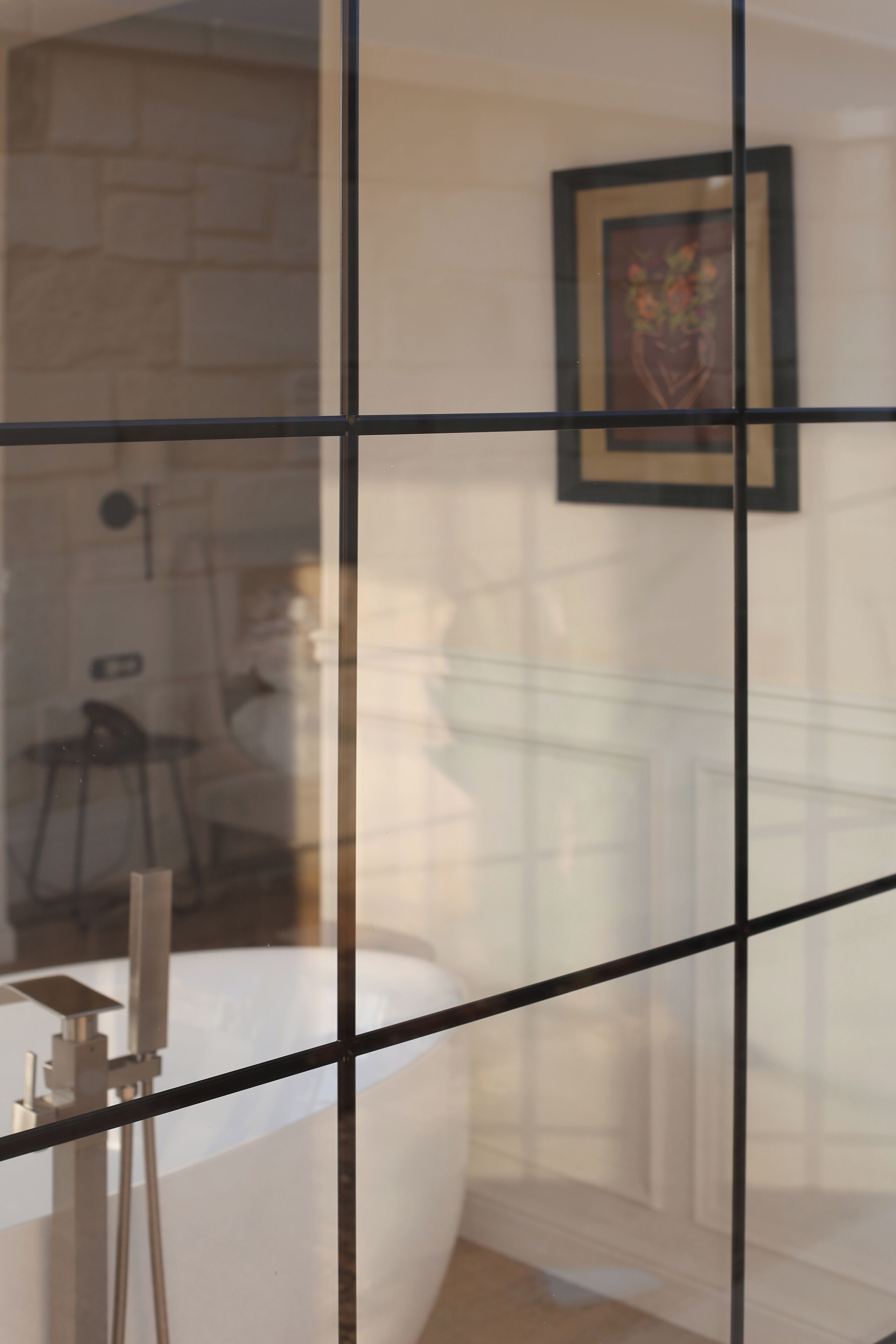 A bathroom with a bathtub, a shower, and a framed artwork on the wall.