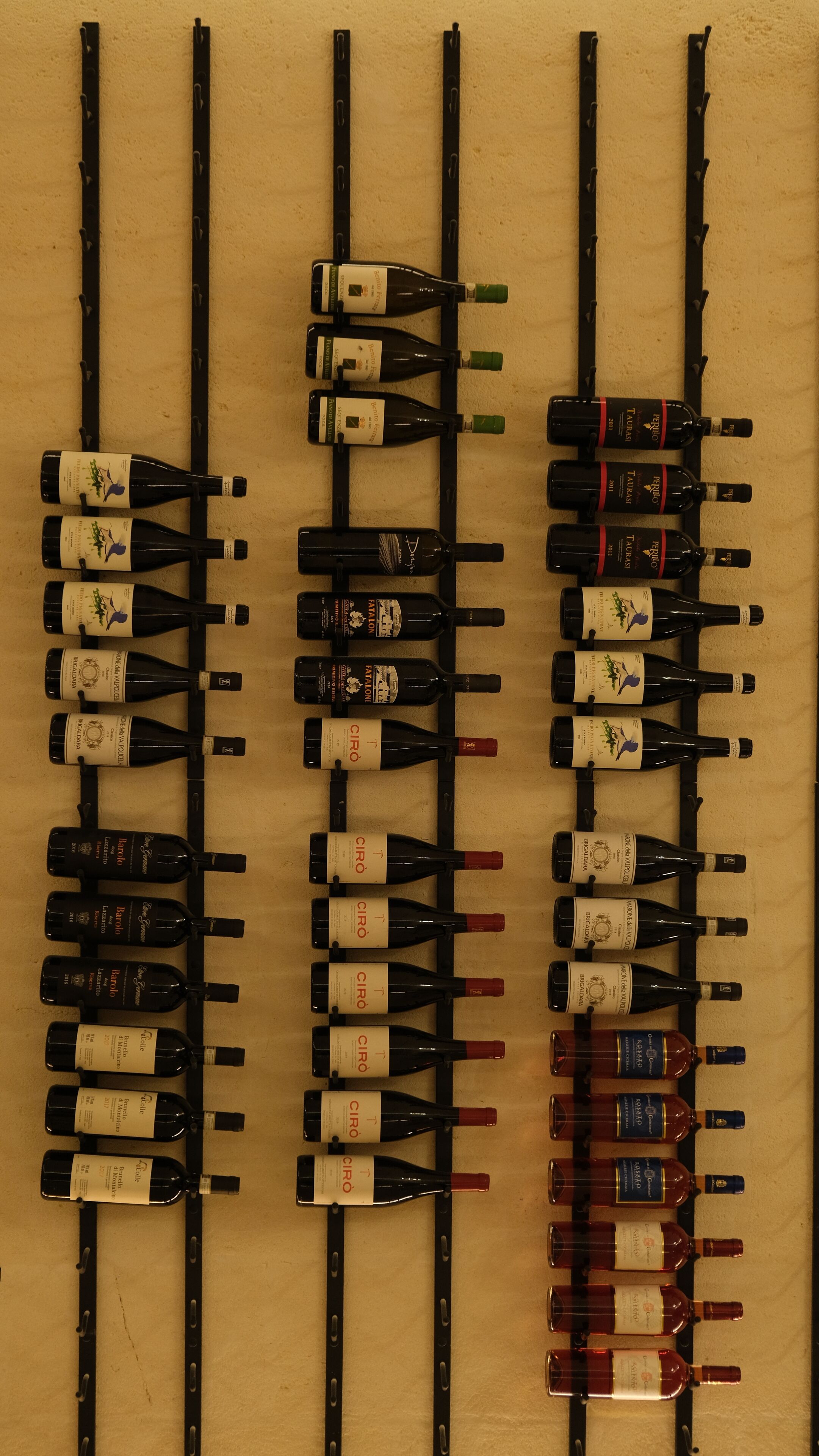 Una estantería con varias botellas de vino.