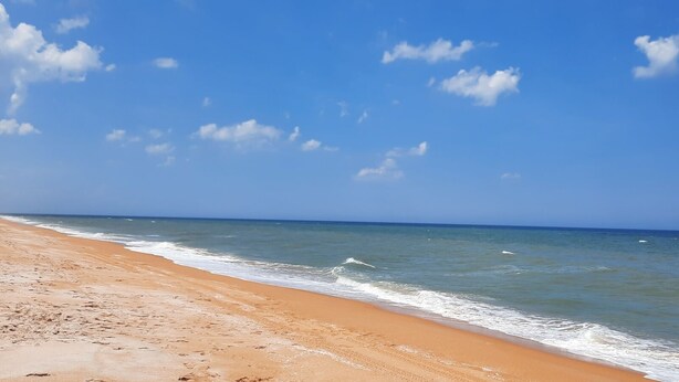 A beach with clear skies and calm waves. - Long term Travelers: spacious 2 BR beach condo (Ormond Beach)
