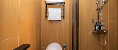 A modern bathroom with a toilet, a towel rack, a shower, and a soap dispenser.