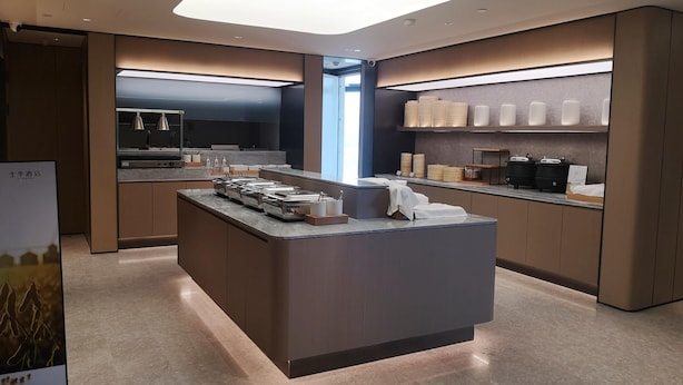 A modern hotel lobby with a central island, a reception desk, and a bar area. - Ji Hotel Hangzhou Songcheng (Hangzhou)