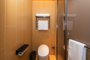 A modern bathroom with a toilet, a towel rack, and a glass shower enclosure. - Ji Hotel Hangzhou Songcheng (Hangzhou)