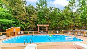 A swimming pool with lounge chairs, a wooden pergola, and a small building, surrounded by trees. - Peaceful Refuge minutes to SDC with Shuttle (Branson)