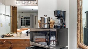 A kitchen area with a microwave, a coffee maker, and a stainless steel pot on the counter. - Peaceful Refuge minutes to SDC with Shuttle (Branson)