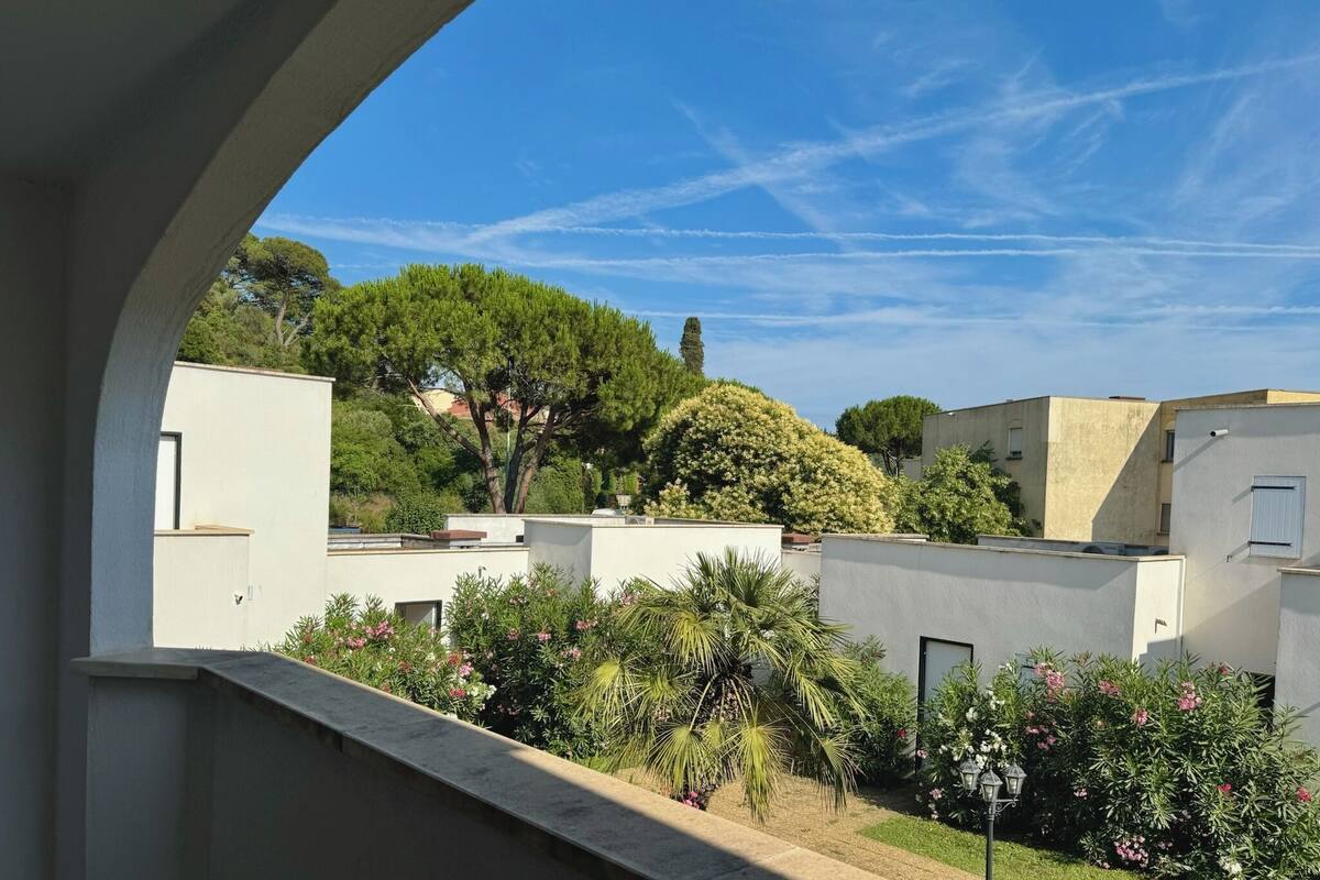 Un patio con edificios, árboles y cielo despejado.