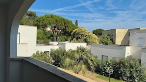 A courtyard with buildings, trees, and a clear sky. - Beach Cannes Bungalows (Le Cannet)