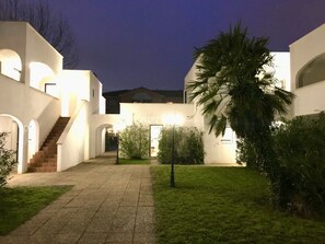Un edificio moderno con un patio central, una escalera y una palmera.