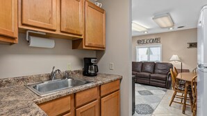 A kitchen with wooden cabinets, a granite countertop, and a coffee maker.