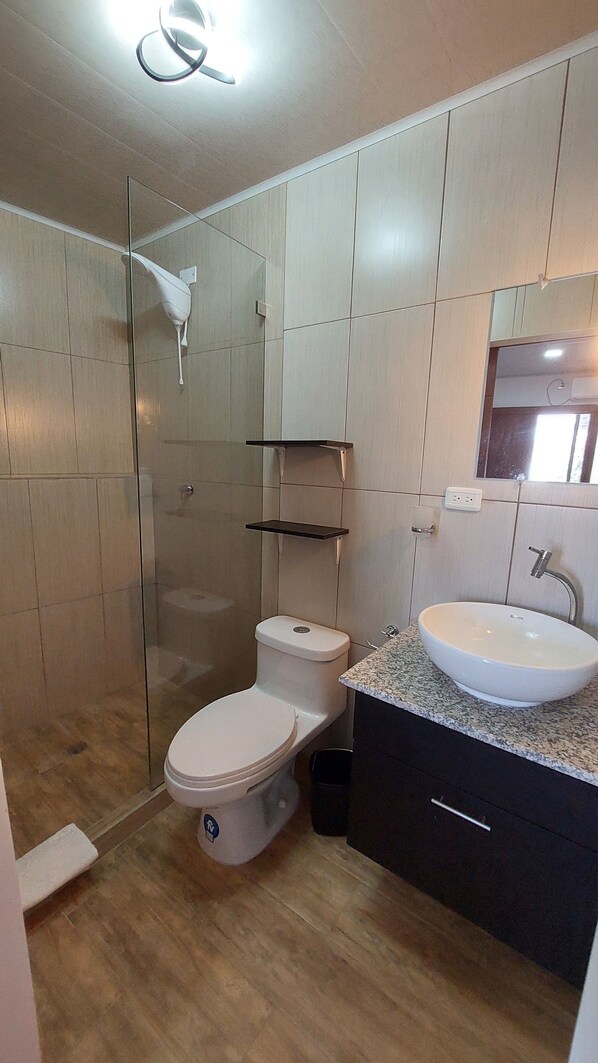 Un baño moderno con inodoro, lavabo y ducha.