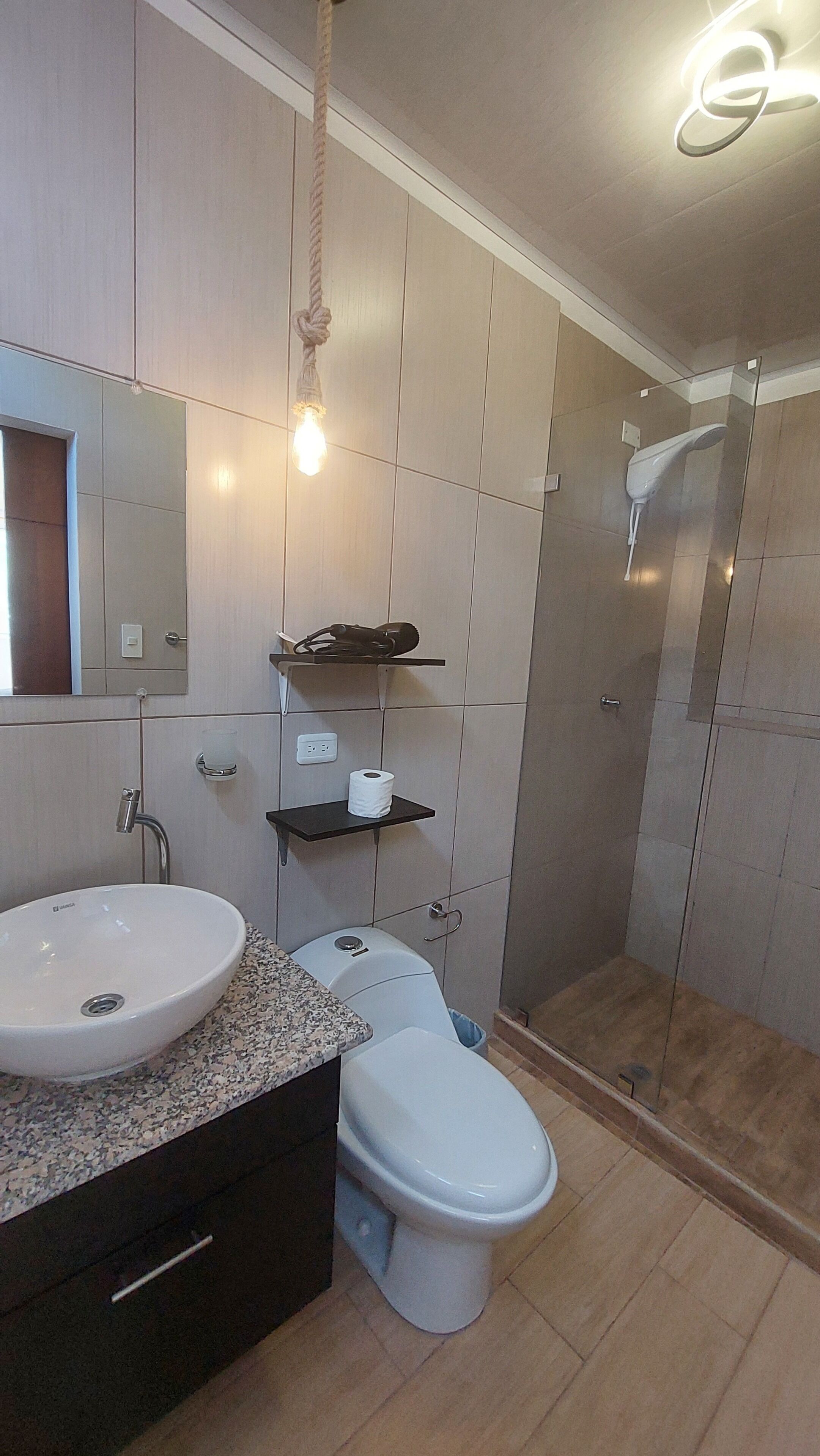 A modern bathroom with a sink, toilet, and shower.