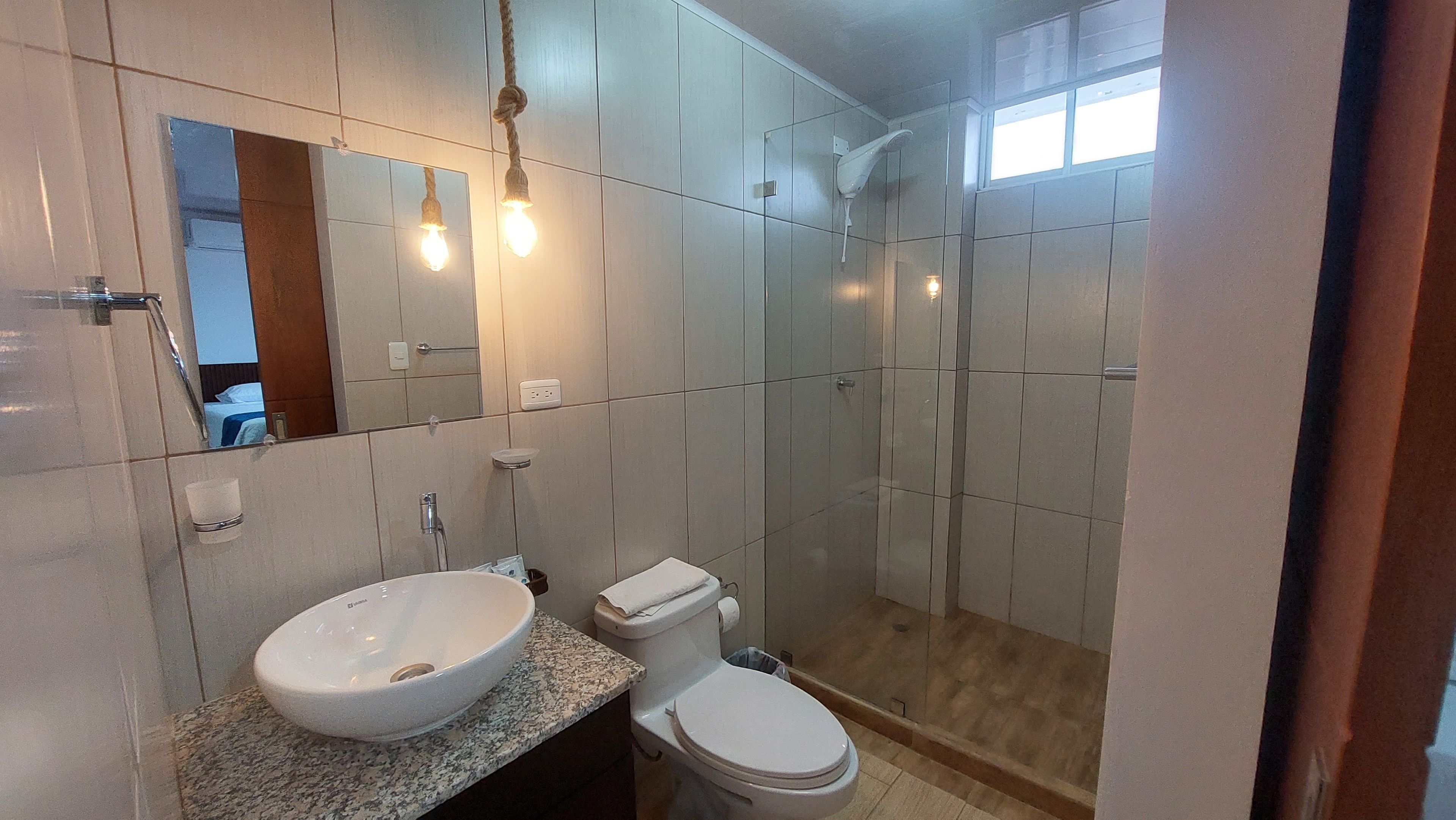 A bathroom with a sink, toilet, and shower.