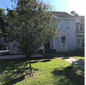 Stunning two-story home with a satellite dish on the roof, a front entrance, and a beautifully manicured lawn.