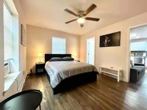 Relax in this serene bedroom with a large bed, ceiling fan, and two bedside tables with lamps.