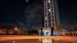 Un immeuble à plusieurs étages, avec une enseigne indiquant « ARAM OTEL » au niveau du rez-de-chaussée.