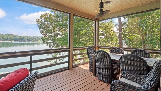 A covered outdoor deck with wicker furniture and a view of a lake. - Central Perk - pet friendly, luxury cabin feel,  coffee! (Crane Hill)