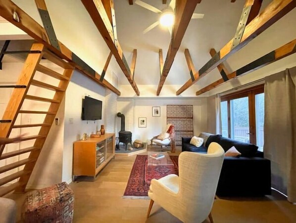 Cozy living area with a sofa, armchairs, and flat-screen TV.