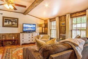 A cozy living room with a television, a sofa, a chair, and a wooden ceiling. - Mucho Gusto in Bandera (Bandera)