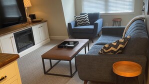 A living room with a TV, sofa, and coffee table.