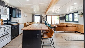 A modern kitchen with a wooden island, black cabinets, and a built-in oven. - Lake Front, Pontoon, Bunk House (Rochert)