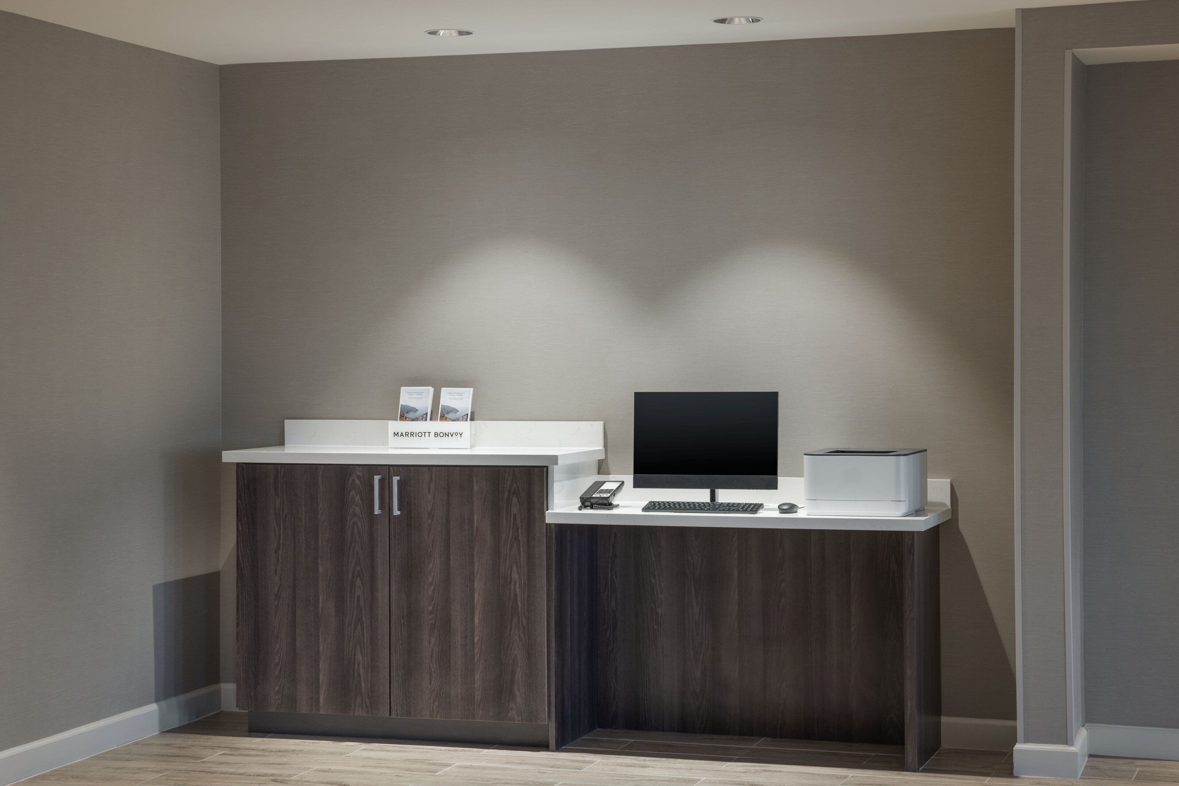 A reception desk with a computer, a phone, and a sign that reads "Marriott Bonvoy."