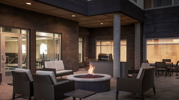 An outdoor patio area with a fire pit, seating, and a grill. - Residence Inn By Marriott Denver Aurora (Aurora)