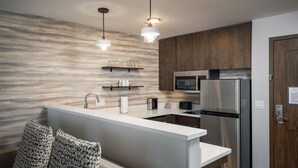 A modern kitchen with a central island, stainless steel appliances, wooden cabinets, and pendant lighting. - Residence Inn By Marriott Denver Aurora (Aurora)