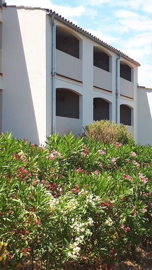 A building with multiple balconies and a garden with various plants and flowers. - Apartment with breathtaking sea view (Banyuls-sur-Mer)