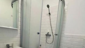 A bathroom with a glass-enclosed shower, a sink, and a toilet.