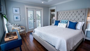 A bedroom with a large bed, a chair, a desk, and a window with blinds. - Townhome Steps to the Beach-Hot Tub, Private Yard (Jacksonville Beach)