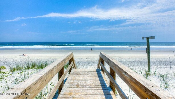 A wooden boardwalk leading to a beach with clear skies. - Townhome Steps to the Beach-Hot Tub, Private Yard (Jacksonville Beach)