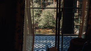 A room with a large window overlooking a forested area.