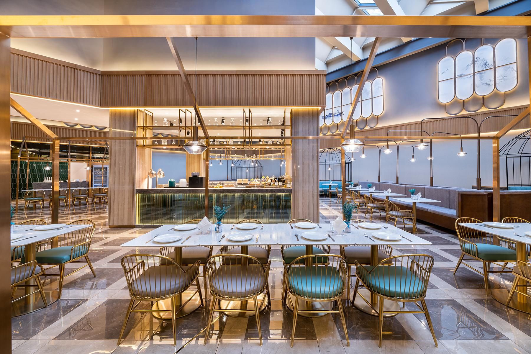Un interior de restaurante moderno con techos altos, asientos escalonados y una zona de bar central.
