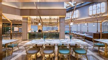 Un interior de restaurante moderno con techos altos, asientos escalonados y una zona de bar central.