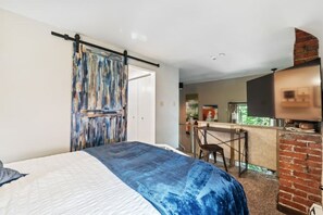 Cozy retreat with a large bed and adjacent kitchen area featuring an oven.