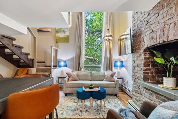 Relax in this inviting living space with a comfortable sofa, dining table, and brick fireplace.