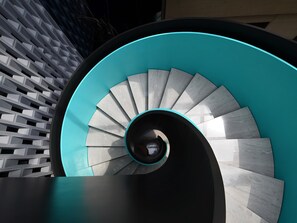 A spiral staircase with teal and white steps, leading upwards. - Blossom Hill Hotel Yangzhou Slender West Lake (Yangzhou)