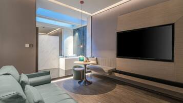 A modern living room with a sofa, a coffee table, and a flat-screen TV mounted on the wall.