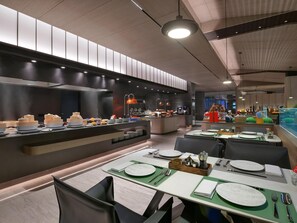 A modern restaurant with a buffet area, dining tables set with plates, cutlery, and napkins. - Blossom Hill Hotel Yangzhou Slender West Lake (Yangzhou)